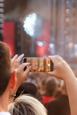 Recording a concert using a mobile phone. Smartphone at music show
