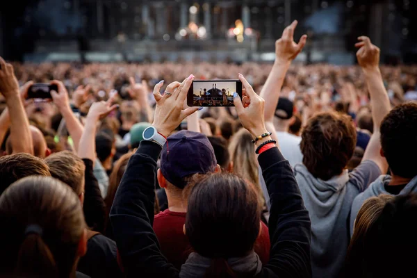 Smartphone in the hand of a music fan at the summer concert