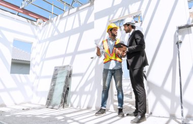 Foreman denetleme mühendisi, inşaat alanındaki inşaat sorunlarını çözmek için proje yöneticisine danışmanlık yapıyor..