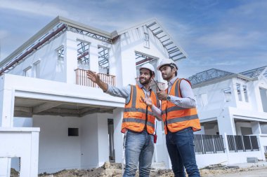Foreman denetleme mühendisi, inşaat alanındaki inşaat sorunlarını çözmek için proje yöneticisine danışmanlık yapıyor..