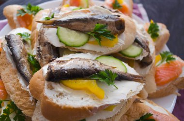 Sandviç, somonlu sandviç ve tabakta sprat. Makro arka plan. Yüksek kalite fotoğraf. Ziyafet, tatil, doğum günü. Beslenme