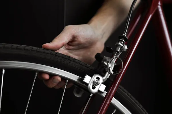 サービス部門の男が自転車の車輪の圧力をチェックします 自転車修理クローズアップ — ストック写真