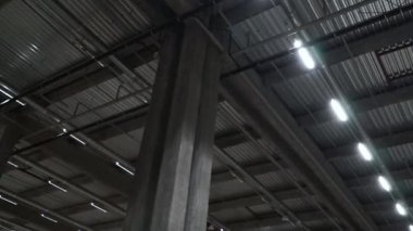 Endüstriyel bir tekstil şirketinin büyük bir deposunun metal tavanı. Büyük deponun tavanında floresan lambaları var.