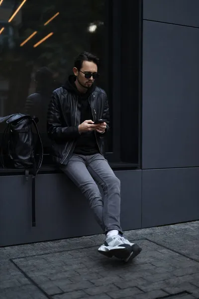 Молодой Стильный Мужчина Черной Куртке Пишет Смс Через Интернет Телефону — стоковое фото