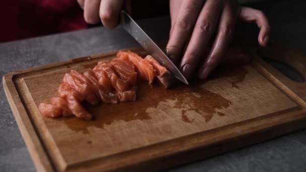 Μια Γυναίκα Κόβει Ψάρια Σολομού Μικρά Κομμάτια Στην Κουζίνα Της — Αρχείο Βίντεο