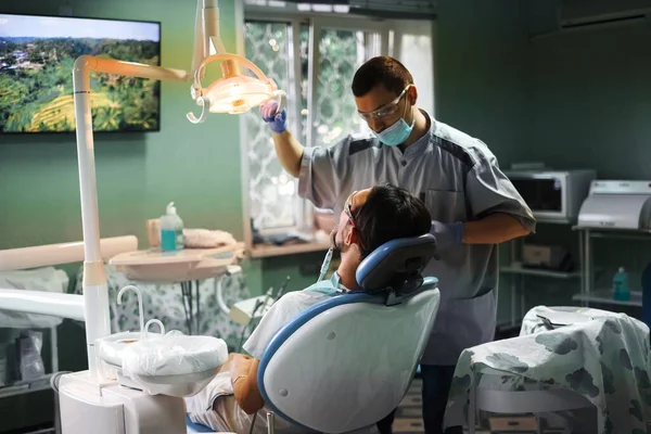 a young man sits in a dentist's chair and treats his teeth