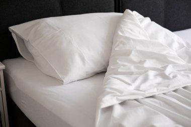 white pillow and blanket on the bed top view. bedding in a hotel room