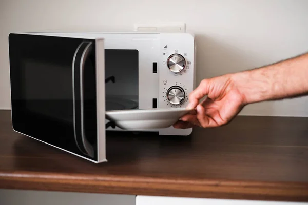 Man Puts Plate Microwave Warm His Food — Fotografia de Stock