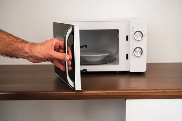 Man Puts Plate Microwave Warm His Food — Fotografia de Stock