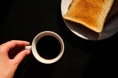 Kahvaltınızda kızarmış ekmek ve siyah masa manzaralı kahve.