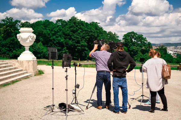 a TV crew filming a news story in a historic building in the center of a European city