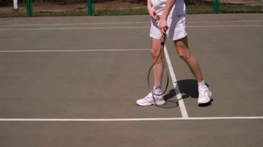 Erkek sporcu tenis oynamadan önce sahada egzersiz yapıyor.