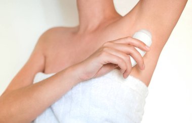 Duştan sonra havlu kadın deodorant kullanıyor.