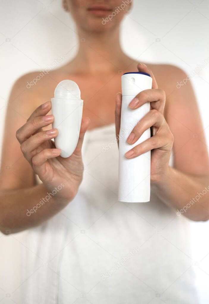 woman holding roll-on deodorant and antiperspirant spray