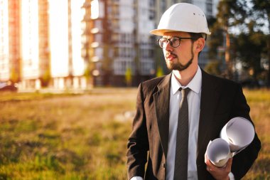 Bir inşaat mühendisi inşa edilmiş evi inceler ve teknik planla karşılaştırır.