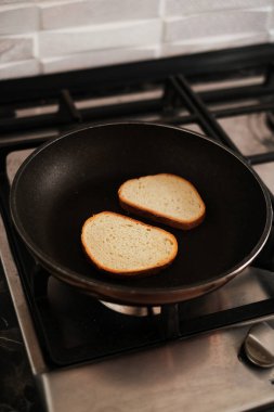 Ekmek gaz sobasında tavada kızarır.