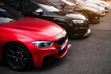 red BMW 530 stands in a row with other cars in a parking lot on the street close-up of the front body Odessa, Ukraine july 2022