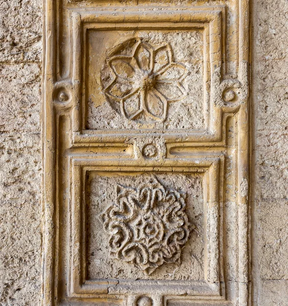 Mamluk döneminin antik taş duvarına oyulmuş iki adet yuvarlak çiçek deseni. Sultan al Muayyad Camii, Kahire, Mısır