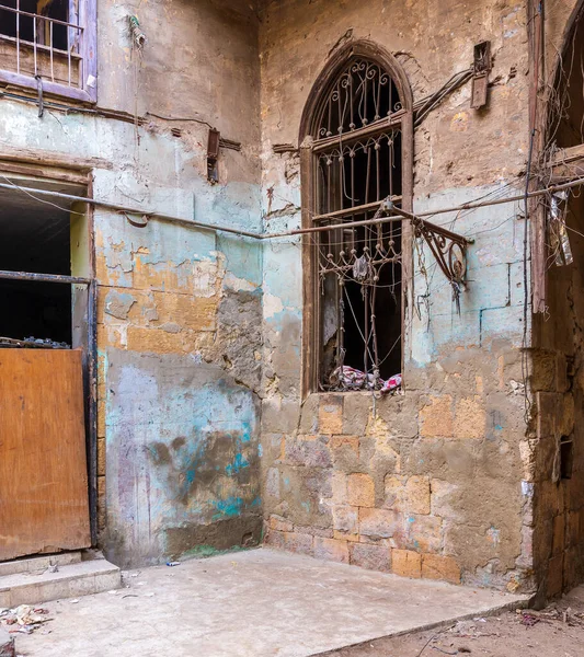 Eski, terk edilmiş tuğla duvarlar, tek bir grunge kırık demir pencere.