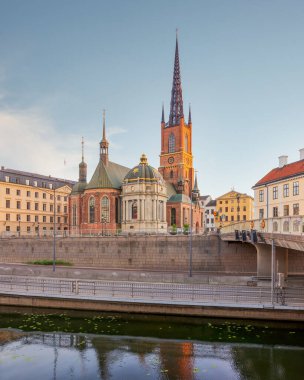 Riddarholmen Church, overlooking Riddarholmskanalen canal, located in the island of Riddarholmshamnen, old city, Gamla stan, Stockholm, Sweden, before sunset in a summer day 