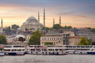 İstanbul, Türkiye - 25 Ağustos 2022: Eminonu 'daki Galata Köprüsü' nden feribot, feribot terminali ve gün batımından önce Süleyman Camii 'ne bakan İstanbul kent manzarası