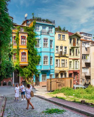 İstanbul, Türkiye - 28 Ağustos 2022: Eski Balat ilçesinde geleneksel renkli eski evler, bir yaz günü turistlerin fotoğraf çektiği
