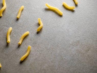 İtalyan yemeği sarısı çiğ vermicelli, makarna, makarna, pasta, izole edilmiş gri fayans üzerinde makarna (yakın çekim, yemek, mutfak, yemek pişirme, gri, kuru, tabak, stüdyo, akşam yemeği, fayans, çimento)