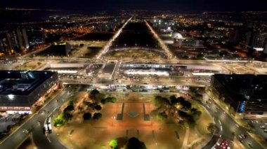 Brezilya 'nın Brasilia şehrinin gece manzarası. Şehir merkezi turizm beldesinde aydınlatılmış meydan ve cadde manzarası.