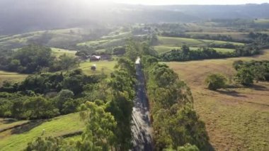 Çiftlik arazisinin yakınındaki kırsal yol. Kırsal kesim manzarası. Kırsal manzarada tek yol.
