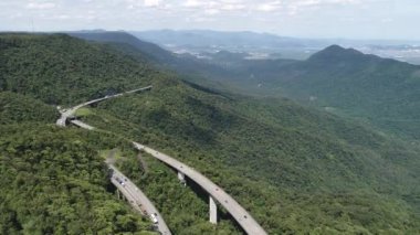 Yeşil orman ağaçları ve dağlardaki Imigrantes karayolu manzaralı. Brezilya 'nın güney kıyısına giden ünlü yolda trafik vardı. Efsanevi mühendislik yapısı. Açık hava yol simgesi..