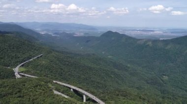 Yeşil orman ağaçları ve dağlarda geniş bir çevre yolu var. Brezilya 'nın güney kıyısına giden ünlü yolda trafik vardı. Çarpıcı mühendislik inşaatı. Ulusal yol simgesi.