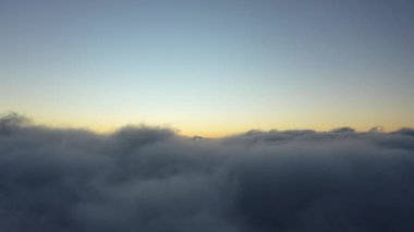 Sisli bir sabah. Bulutların üzerinde güneş ışınları. Güneş ışığı havası. Gün doğumu bulutlu gökyüzü. Sis sabahının geniş hava manzarasını tarıyorum..