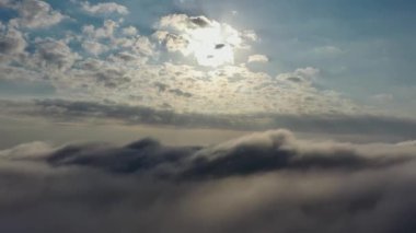 Sisli bir sabah. Bulutların üzerinde güneş ışınları. Güneş ışığı havası. Gün doğumu bulutlu gökyüzü. Sis sabahının geniş hava manzarasını tarıyorum..