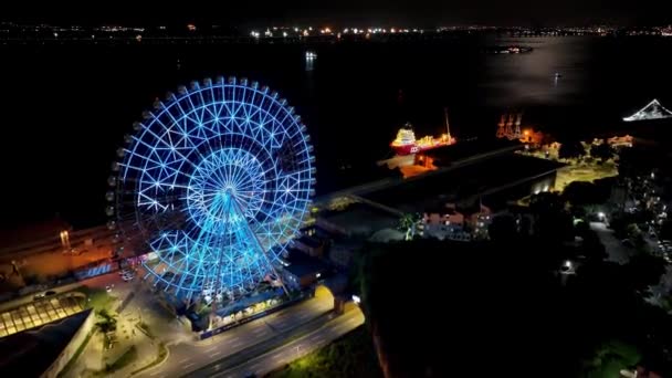 リオデジャネイロのダウンタウンにある遊園地の街 リオデジャネイロのダウンタウンでライトアップされた観覧車の夜のパノラマ風景 有名な港区観光都市のランドマーク — ストック動画