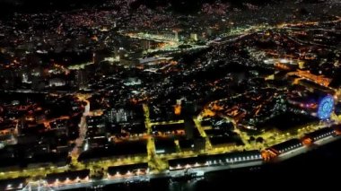 Rio de Janeiro Brezilya şehir merkezindeki lunapark manzarası. Rio de Janeiro Brezilya şehir merkezindeki aydınlanmış dönme dolabın gece panoramik manzarası. Şehrin ünlü liman bölgesi turizmi.