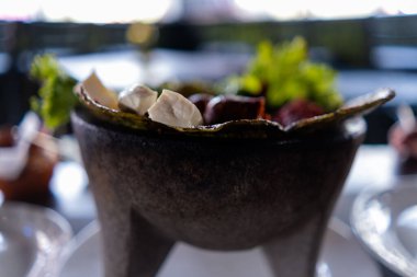 Beyaz peynir dilimleri, sucuk ve Meksika molcajete 'sinde kavrulmuş nopales.