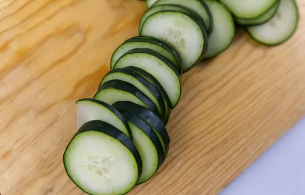 Concombre frais tranché sur une planche à découper en bois — Photo