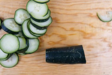 Tahta kesme tahtasının üzerinde taze kesilmiş salatalık.