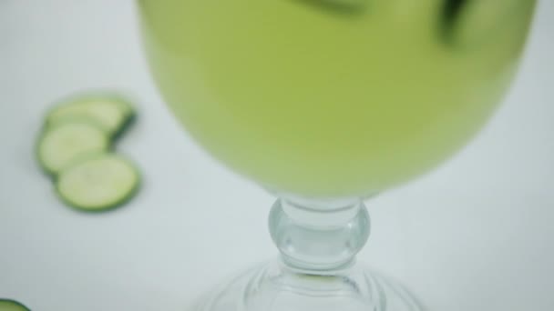 Beyaz yüzeyde salatalık ve limon ferahlatıcı içecek. — Stok video