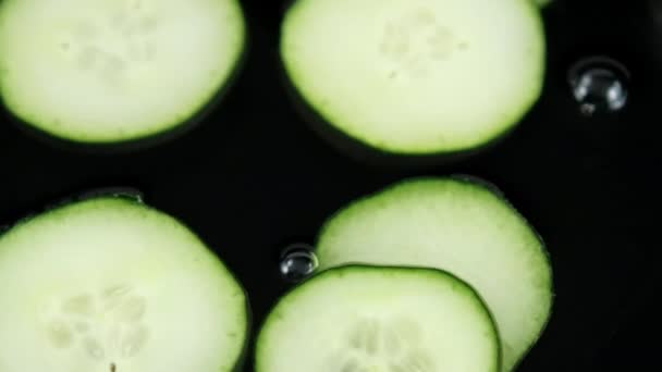 Närbild av gruppen färska gurkskivor som flyter i vätska — Stockvideo
