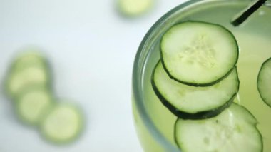 Beyaz yüzeyde salatalık ve limon ferahlatıcı içecek.