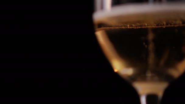 Close-up van bubbelig bier in een glazen beker met zwarte achtergrond — Stockvideo