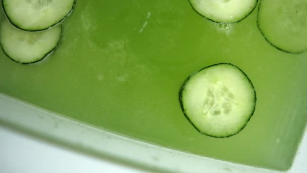 Boisson rafraîchissante au concombre dans un récipient en verre au-dessus de la surface blanche — Video