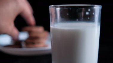 Siyah arka planı olan bir kurabiye bardağına daldırmak.