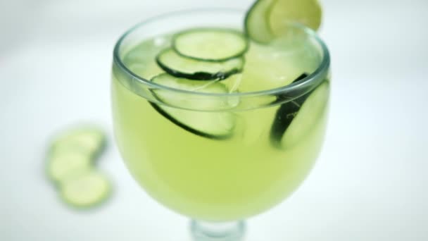 Beyaz yüzeyde salatalık ve limon ferahlatıcı içecek. — Stok video