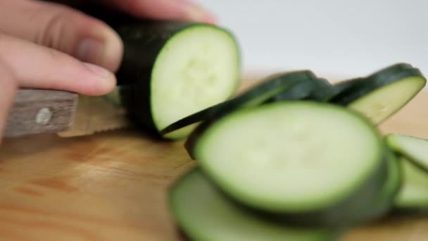 Manos rebanando pepino fresco en una tabla de cortar de madera — Vídeo de stock