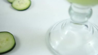 Beyaz yüzeyde salatalık ve limon ferahlatıcı içecek.