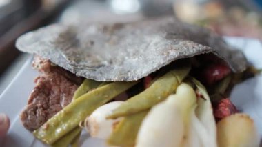 Meksika yeşil soğanı, nopales ve ince bifteklerin üzerine siyah mısır tortilla.