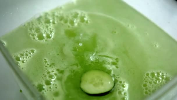 Kawałek ogórka wpadający do orzeźwiającego zielonego napoju w szklanym pojemniku — Wideo stockowe