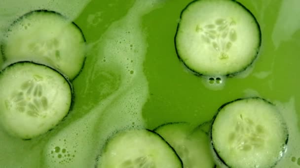 Gurkskivor flyter i uppfriskande och skummande grön dryck — Stockvideo